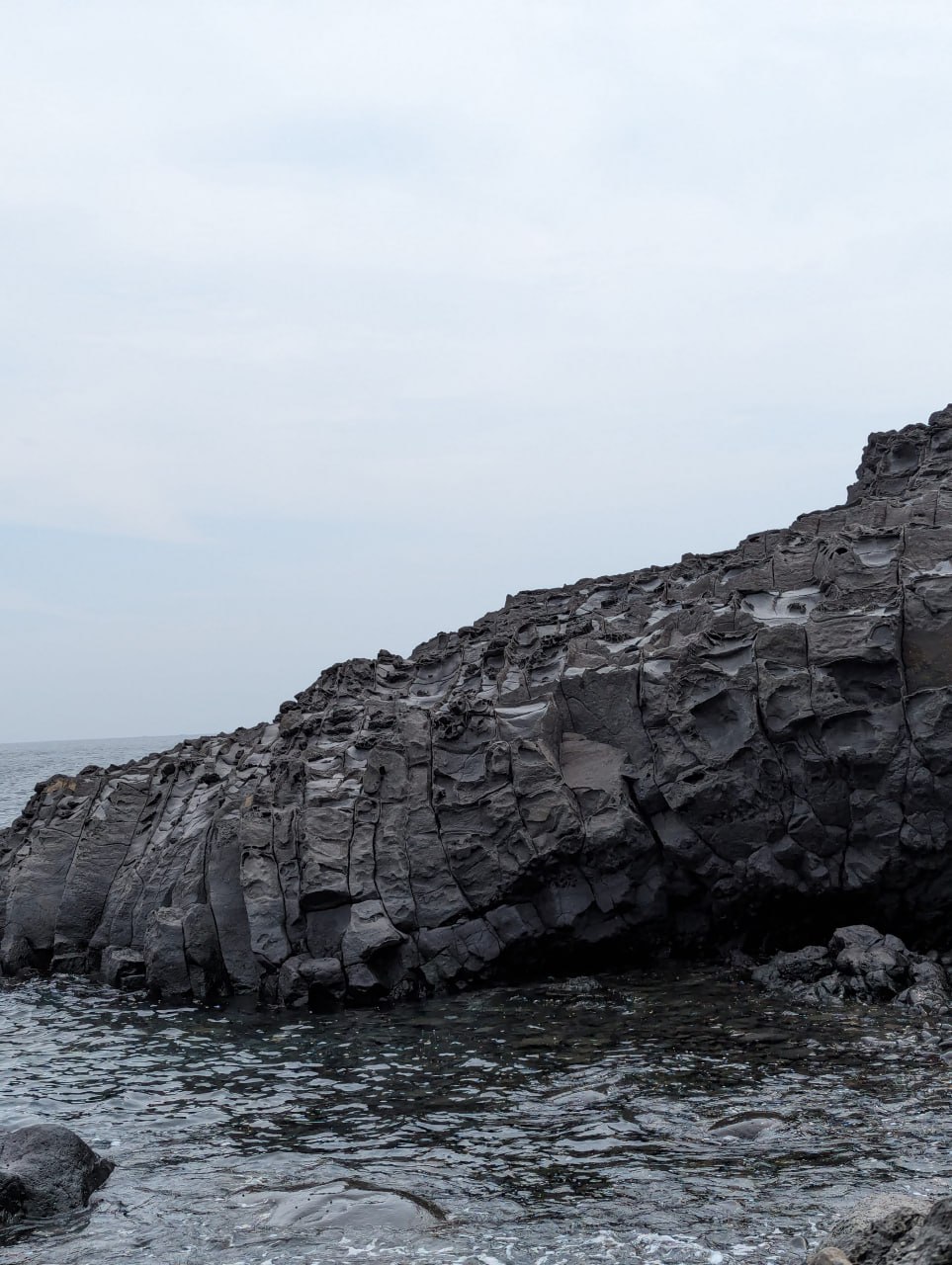 Побережье, ракушки и вулканические камни